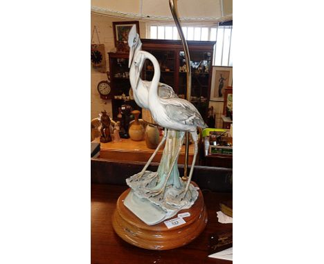 An R. Pennati porcelain table lamp sculpture of a pair of storks on wooden base, impressed mark "Florence 1984"