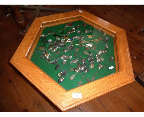 Light oak octagonal display table (vitrine) on turned legs, together with a collection of souvenir spoons