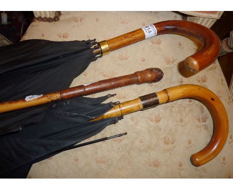 Two vintage gent's umbrellas, one with 18ct gold band, the other by Briggs, with a silver band. Together with a cane and leat