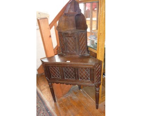 Late Victorian carved oak corner table on turned with corner shelf above