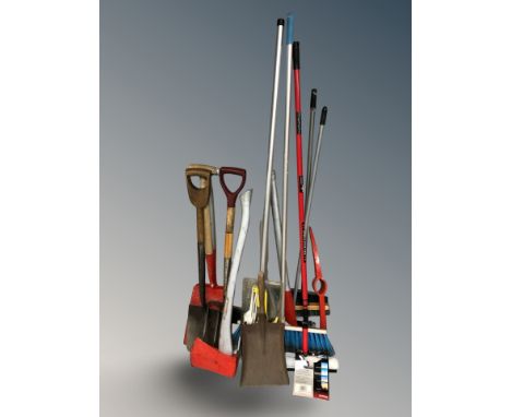 A group of tools, brush, tree lopper, axe, spades, etc.