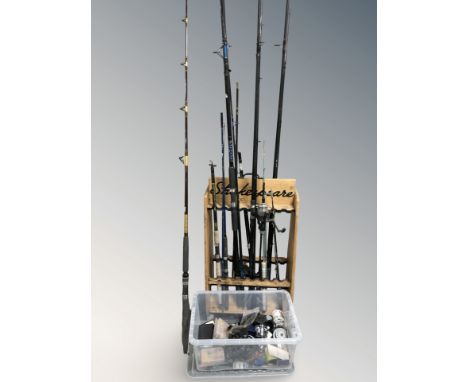 A group of fishing related items, large quantity of reels, lures, wooden rack containing fish rods