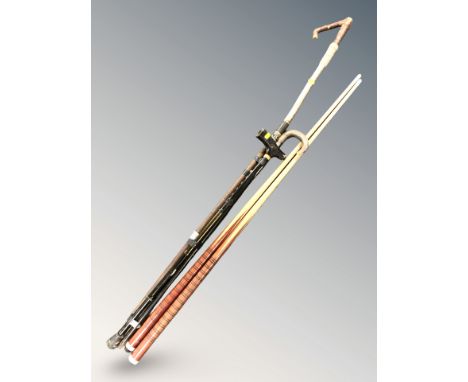 A group of sticks, a walking stick and two snooker cues including an antique swordstick. 