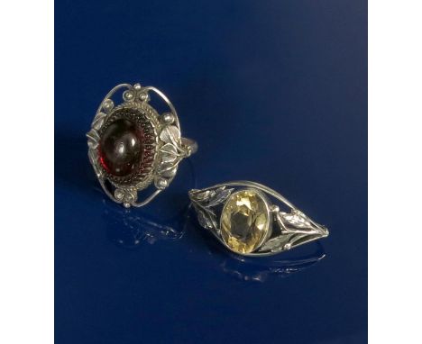 A silver ring, the pierced frame with foliate motif, set with modelled ruby glass panel, and a silver and citrine scarf ring,