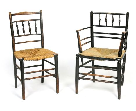 An ebonised wood Sussex armchair probably Morris & Co, with turned bobbin back and rush seat, and a similar side chair, 83cm.