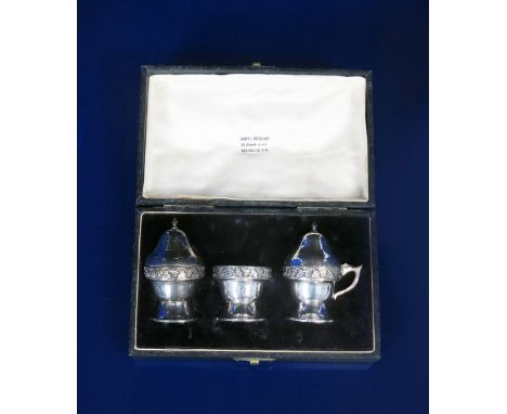 A silver cruet set by Sibyl Dunlop, comprising salt with glass liner, pepper pot and cover and a mustard pot with hinged cove