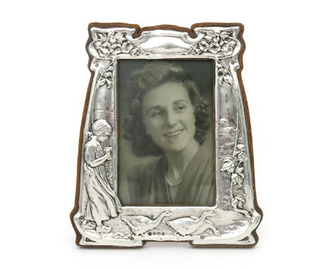 A Charles S Green & Co silver photo frame, mounted on wood with easel back, stamped in low relief with a young girl feeding t