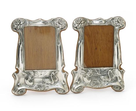 A pair of silver plated copper photograph frames, on wooden mount with easel back, stamped in low relief with a fairy riding 