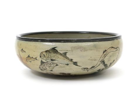 An unusual Martin Brothers stoneware Aquatic bowl by Robert Wallace Martin, dated 1886,  incised with a shoal of fish includi