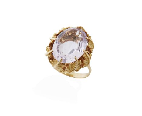  A mid 20th century amethyst cocktail ring  Claw-set with an oval-cut amethyst, with foliate detail to gallery, plain band, i