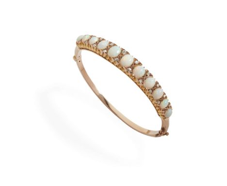  An opal and diamond bangle  Of hinged design, claw-set with eleven graduated cabochon opals between pairs of rose-cut diamon