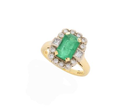  An emerald and diamond cluster ring  Claw-set with a rectangular step-cut emerald, in a border of round brilliant and prince
