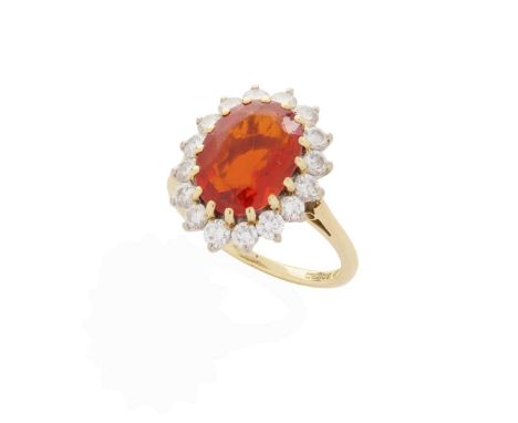  An 18ct gold fire opal and diamond cluster ring  Claw-set with an oval-cut fire opal, weighing approximately 3.01cts, in a b