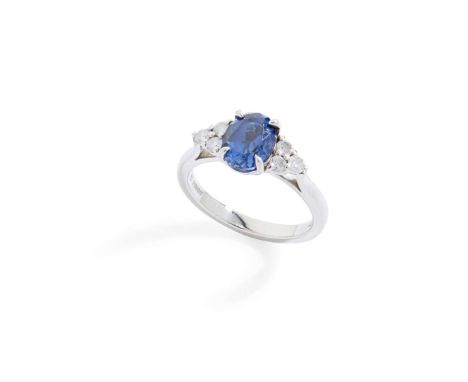  A platinum sapphire and diamond ring  Claw-set with an oval-cut sapphire, each shoulder set with three round brilliant-cut d