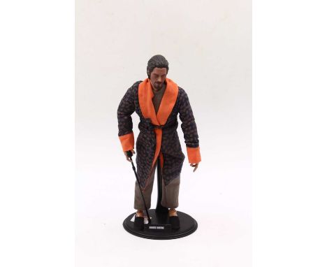 A 1/6 scale loose action figure of a Bruce Wayne ‘The Dark Knight Trilogy’ holding a walking stick, with a stand (appears to 