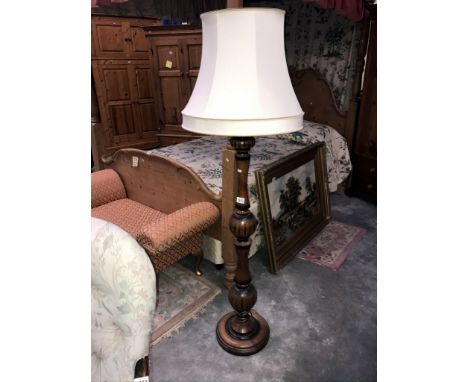 A large wooden standard lamp with shade