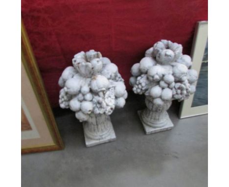 A pair of gate post finials of fruit and flowers.