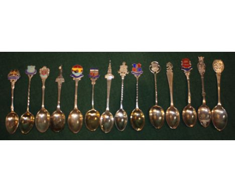A COLLECTION OF SEVEN SILVER AND ENAMEL COMMEMORATIVE TEASPOONS with place names and seven silver commemorative spoons, 6.2 t