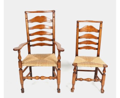 A MATCHED SET OF SIX 19TH CENTURY ASH LADDER BACK DINING CHAIRS with rush seats, turned and tied supports, two carvers and fo