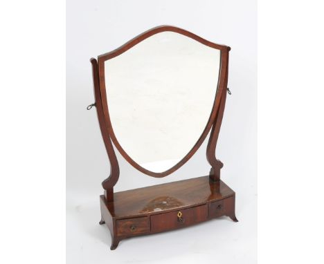 A GEORGE III MAHOGANY SWING TOILET MIRROR with shield shaped plate and bow fronted box base fitted three drawers on splayed b