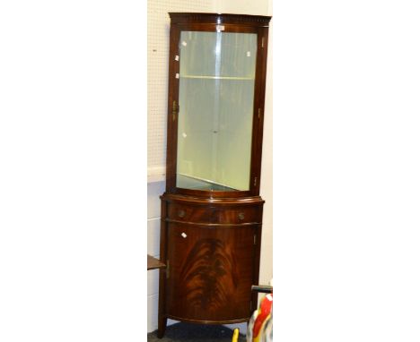 A 20th Century mahogany bow fronted corner cupboard,  top with glazed front and display shelves