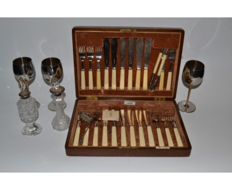 An oak cased set of flatware, three  stainless steel and gold plated Viner's goblets from the Stuart Devlin collection, a pai