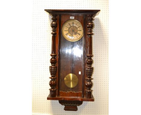 An early 20th Century walnut Vienna wall clock, the face flanked by turned columns  