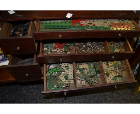 Meccano- 1930s and later contained in a counter top seven drawer chest and bag inc clock work motor, tyres, gears, panels etc