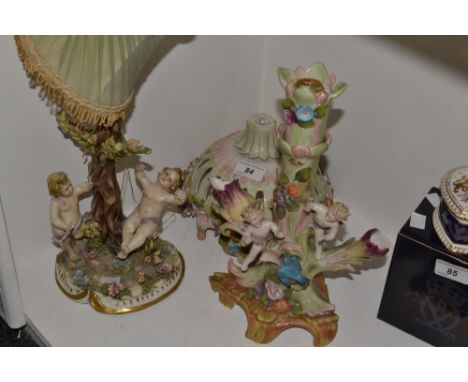 A continental porcelain figural lamp base , two cherubs on a garden swing, a continental porcelain sweetmeat dish (faults)(2)