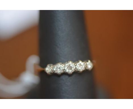 A five stone set diamond ring on yellow metal band, marked 18ct