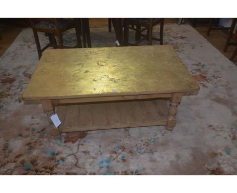 A stripped pine coffee table, the plain rectangular gilded top with plain frieze, block supports, under shelf, 47cm x 122cm x