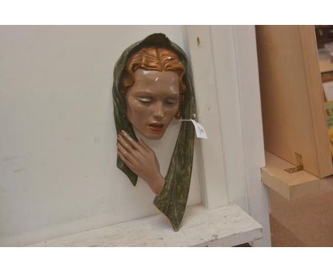 A vintage wall plaque of a woman's head in scarf in painted plaster