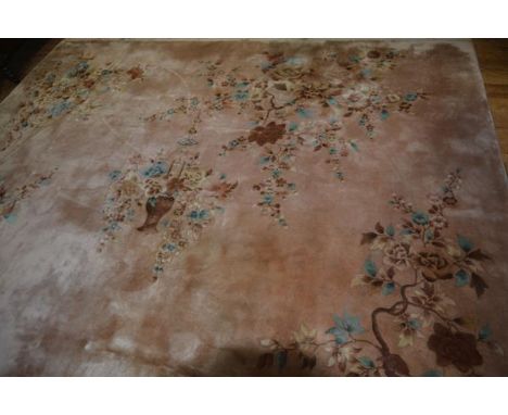 A Chinese wool carpet decorated with urn and floral sprays, with all over floral and leaf decoration, on pink field, 350cm x 