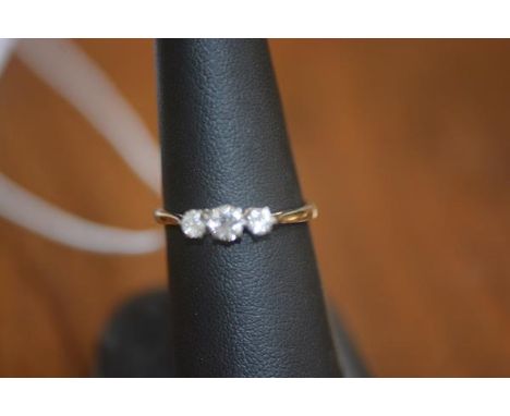 A three stone diamond ring on white metal band