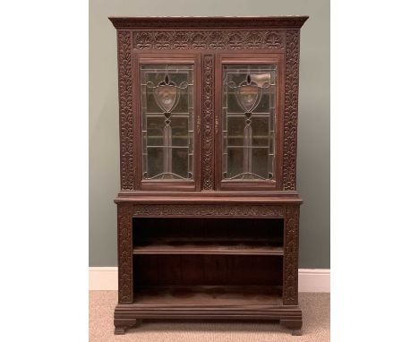 EDWARDIAN CARVED OAK BOOKCASE circa 1900, having an open two shelf base, below elaborately leaded glass upper doors, all arou