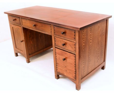 A heavy modern oak kneehole desk - the overhanging top over a central fold-down faux drawer with keyboard slide and two small