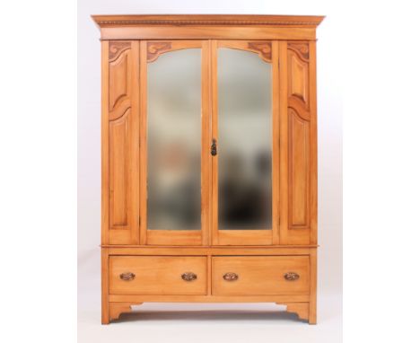 An Edwardian satin walnut double wardrobe - the ogee moulded and egg and dart carved cornice over a pair of mirrored doors fl