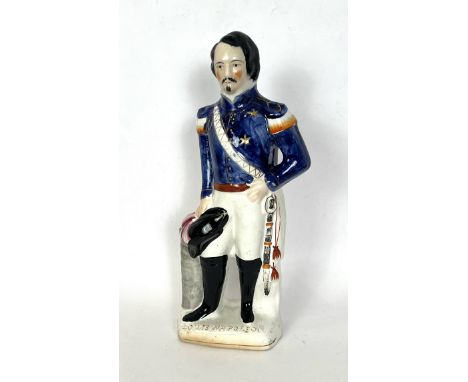 A large 19th century Staffordshire figure of Louis Napoleon - standing in military attire and in relaxed pose, holding his fe