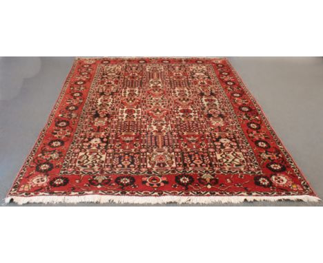 A Persian Bakhtiari hand-knotted wool rug - second half 20th century, panel design, with 45 dark-blue, red and ivory floral p