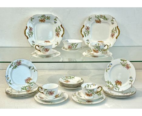 An Aynsley part tea service, 1920s-30s - painted with honeysuckle flowers, comprising two twin-handled sandwich plates; twelv