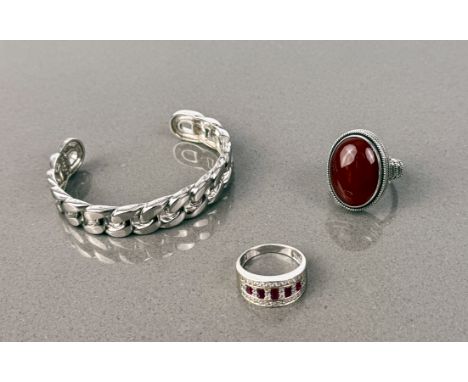 An ornate .925 silver dress ring set with red and white cut stones, size T, a .925 silver ring set with a polished bloodstone