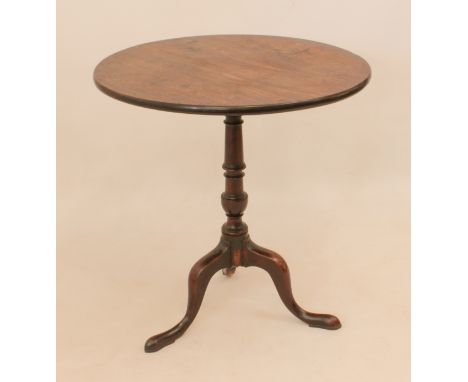 A George III mahogany tilt-top tripod table - the circular top on a turned column to three swept supports with pointed pad fe