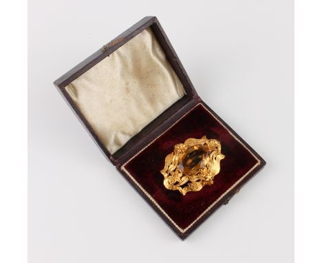 A mid-19th century 18ct gold and citrine brooch - the 21.5 x 14.5mm oval, mixed cut citrine centred on a openwork foliate cha