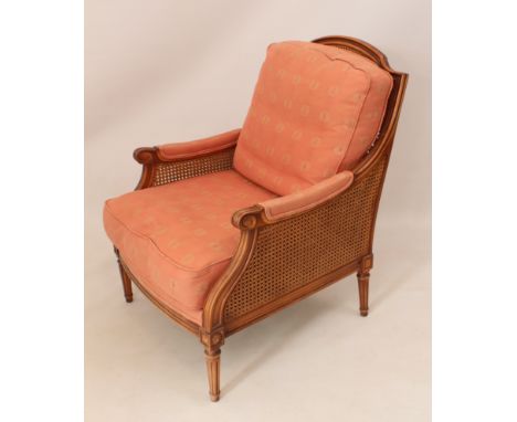 A French-style carved beech and cane berg&egrave;re-style armchair by Wesley-Barrell - the moulded arched back and seat with 