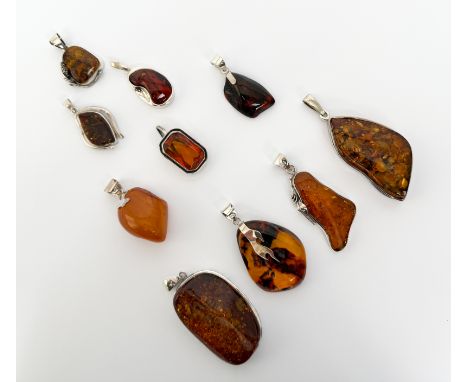 Ten sterling silver and Baltic amber pendants - of varying forms, nine polished, one faceted, the size ranging from 3.2cm to 