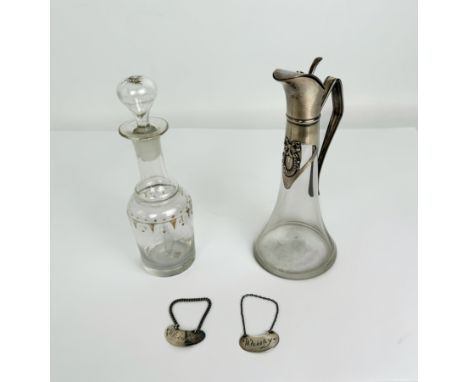 A small 19th century glass spirit decanter and stopper, a small c.1900 glass spirit jug with white metal mounts (both 20cm hi