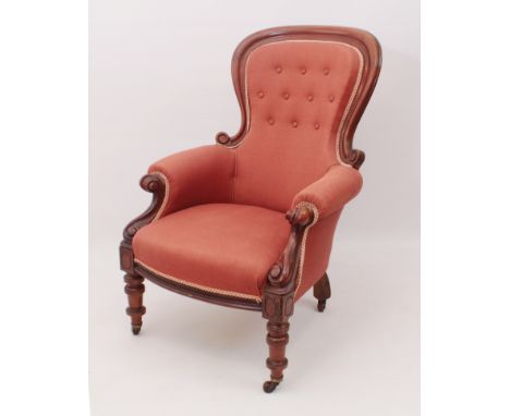 A Victorian carved walnut showframe armchair - the buttoned spoon back over scroll carved arms, upholstered in coral red fabr