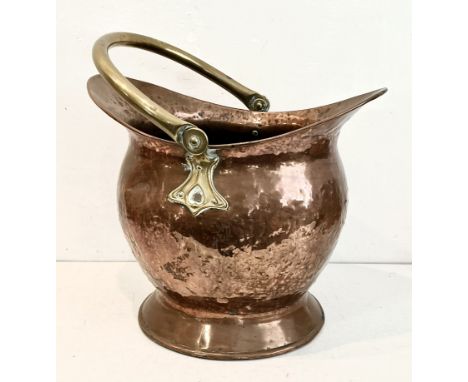 An Arts &amp; Crafts style copper and brass coal scuttle - c.1900, helmet form with flared base and brass swing handle on hea