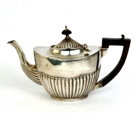 An Edwardian silver teapot - Birmingham 1902, half-gadrooned oval form, composition handle and finial, 24cm long, gross weigh