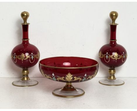 An enamelled and gilt ruby glass pedestal bowl and a pair of matching decanters - probably Bohemian, mid-20th century, the sh